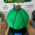 Un Slam Ball fait maison sur un tapis de gym avec des équipements de fitness autour.