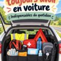 Une femme souriante dans sa voiture, entourée de ses objets essentiels pour conduire sereinement.